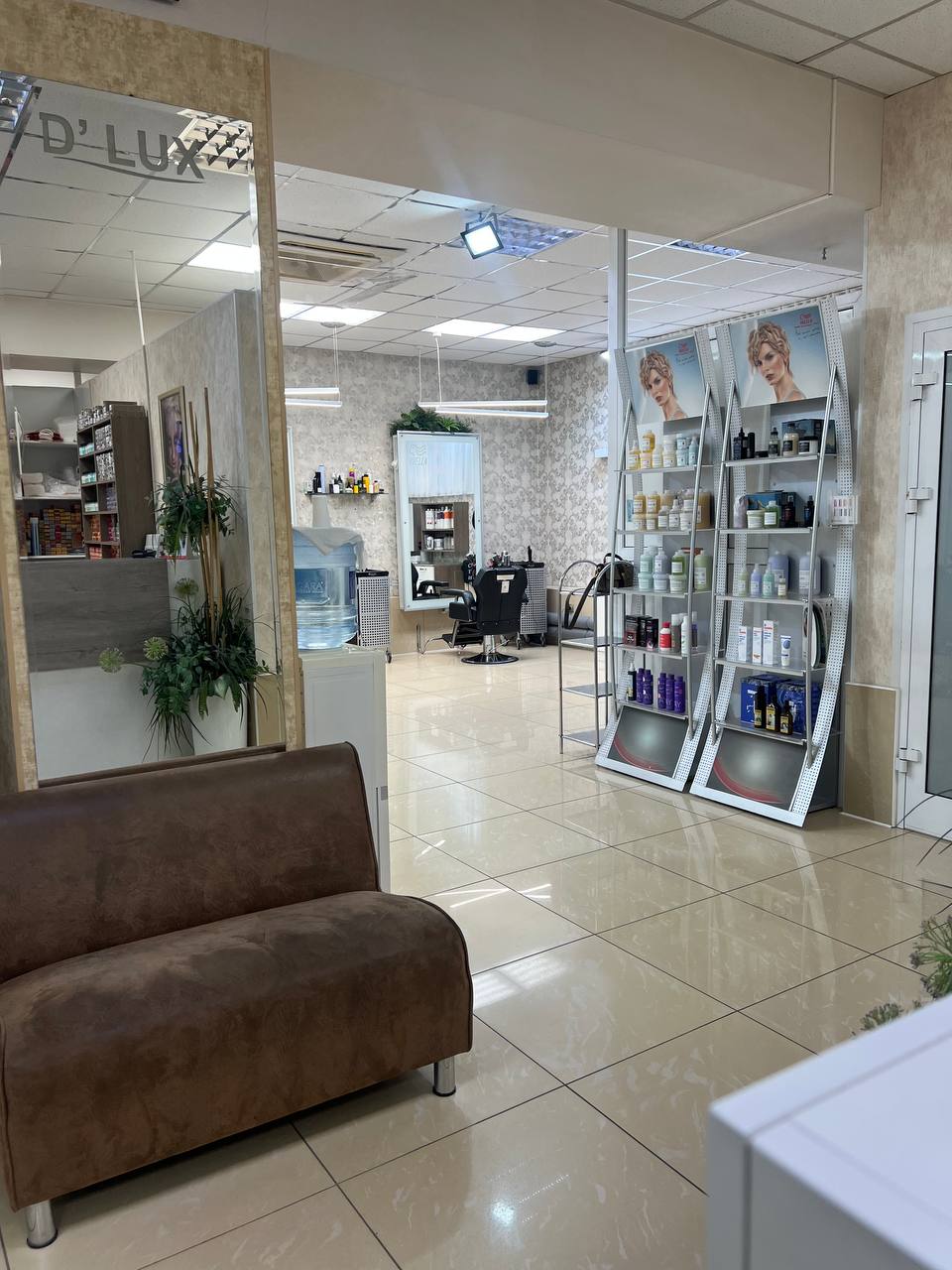 Зона ожидания: диван, зеркало с гравировкой D'LUX, витрины Wella